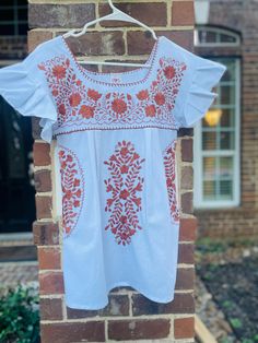 UT Shirt, Authentic Mexican Women's Shirt, Made by artists in Mexico, White with beautiful full burnt orange embroidery and fashionable ruffled sleeves. Made with lightweight Mantra Cotton. Perfect for Game Days. Easy fit and great length  Colors and designs may vary slightly as these are hand made in Mexico Care:  For best care we suggest hand washing and line dry Bohemian Blouse With Floral Embroidery And Flutter Sleeve, Bohemian Tops With Floral Embroidery And Flutter Sleeve, Summer Embroidered Blouse With Flutter Sleeves, Cotton Blouse With Flutter Sleeves And Floral Embroidery, Casual Blouse With Floral Embroidery And Ruffle Sleeves, Cotton Tops With Floral Embroidery And Ruffle Sleeves, Traditional Summer Top With Ruffles, Embroidered Cotton Blouse With Flutter Sleeves, Peasant Style Short Sleeve Tops With Embroidered Border