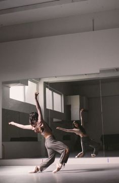 three young men are dancing in an empty room