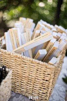 a wicker basket filled with business cards on top of a table next to a bottle of wine