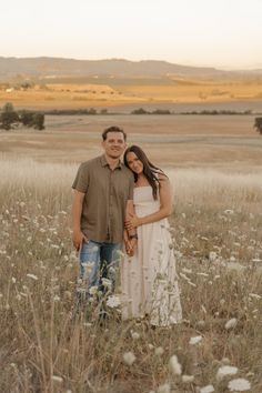 a man and woman are standing in the middle of a field