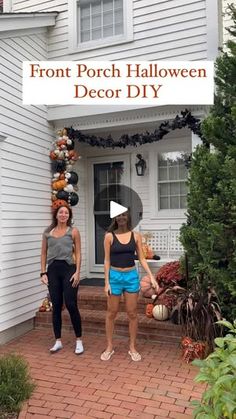 two women standing in front of a white house with pumpkins on it's porch