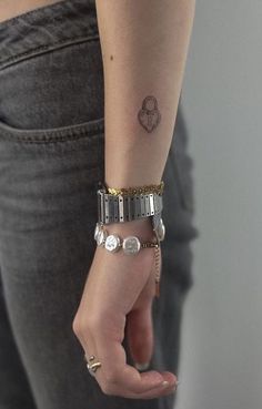 a woman's arm with a small tattoo on the left side of her wrist