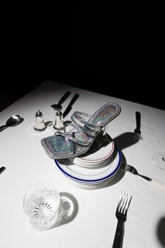 a table topped with plates and silverware on top of a white table