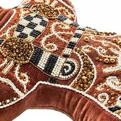 a brown and white decorative pillow with beaded designs on it's back side