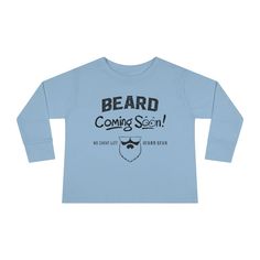 The Beard Coming Soon Toddler Long Sleeve Shirt is one of the newest shirts in our collection. The new Beard Coming Soon Toddler Long Sleeve Shirt is the perfect long sleeve for the cold season. Designed to bring the best to the youngest of us all, it is made stylish, comfortable, and easy to put on. The ideal long sleeve for little ones, with high-quality fabric that feels like a gentle hug. 100% combed ringspun cotton Light fabric Toddler unisex fit Neck and shoulder tape prevents stretching S Winter Long Sleeve Graphic Shirt, Relaxed Fit Long Sleeve Winter Shirt, Winter Long Sleeve Relaxed Fit Shirt, Trendy Blue Winter Shirt, Basic Blue Tops For Winter, Basic Blue Winter Tops, Casual Blue Long Sleeve Top For Winter, Long Sleeve Cotton Shirt With Letter Print, Cotton Long Sleeve Shirt With Letter Print