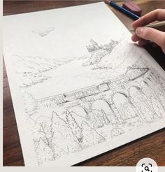 a person is drawing on paper with a pencil