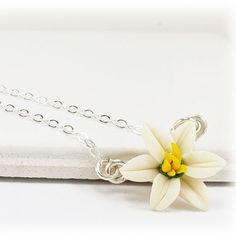 A minimalist style is featured with this petite white Easter Lily necklace for an everyday simple flower necklace. Choose your chain length as a choker necklace or longer.  The tiny Easter Lily necklace flower measures approximately 12mm and is available in white or pink and on a choice of silver-plated, gold-plated, antique brass, 925 sterling silver or 14k gold filled components.  Perfect for any occasion, formal or everyday wear. -Original hand sculpted polymer clay flower, durable, water-resistant, no molds, no paint- -Flower size : approximately 12mm -Metal Components : Choose silver-plated, gold-plated, antique brass, 925 sterling silver or gold filled -Length : Choose 16 or 18 inch chain Color : White View matching collection at:  https://www.etsy.com/shop/strandedtreasures/search?s Everyday Delicate Flower Charm Necklace, Delicate Flower Charm Necklaces For Everyday, Small White Sterling Silver Necklace, Small White Sterling Silver Necklaces, Simple White Sterling Silver Necklace, Minimalist Flower Charm Necklaces For Everyday, Small White Dainty Jewelry, Handmade Minimalist Flower Necklace, White Flower Necklace With Delicate Chain For Gift