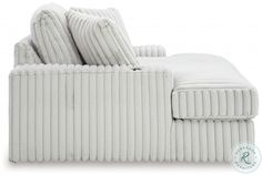 a white corded couch with pillows on it's back and the seat upholstered