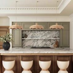 a kitchen with green cabinets and marble counter tops, along with four white stools