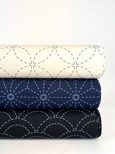 three sheets stacked on top of each other in different patterns and colors, with one folded down