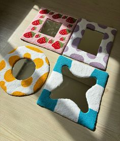 three bathroom rugs on the floor with mirrors and other items in them, one is shaped like an animal