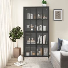 a living room filled with furniture and a book shelf next to a couch in front of a window