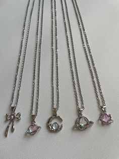 These beautiful necklaces are hand made with a 48cm stainless steel chain. On the chain, hangs a stunning silver plated, iridescent, pink pendant with various unique designs to choose from! It is perfect for daily wear or as a gift to a friend or a loved one!   Styles  ☆ Bella ☆ Comet   ☆ Luna ☆ Astra ☆ Esther  !! These charms have a unique pink colour that changes with different angles and lighting !! ♡ The chain is stainless steel and is approximately 19 inches in length. ♡ The colours may var Cute Silver Clavicle Chain Jewelry, Silver Alloy Heart Pendant Charm Necklace, Silver Heart-shaped Crystal Necklace With Clavicle Chain, Silver Crystal Clavicle Necklace With Heart Pendant, Cute Silver Charm Necklaces With Clavicle Chain, Heart Shaped Silver Alloy Charm Necklace, Silver Round Crystal Necklaces For Valentine's Day, Silver Crystal Necklace For Valentine's Day, Silver Heart Necklace With Adjustable Chain In Stainless Steel