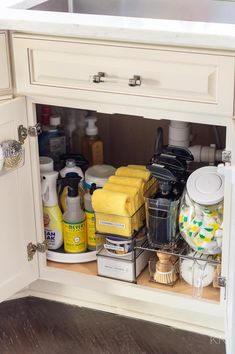 the kitchen cabinet is full of cleaning supplies