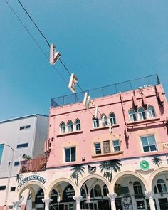 an old pink building with palm trees on the roof and balconies above it