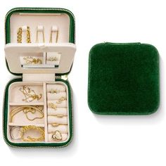 an open green case with jewelry in it on a white surface and the contents inside