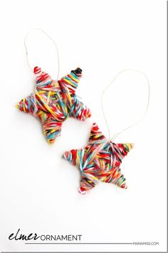 two christmas ornaments made out of candy canes are hanging from strings on a white background