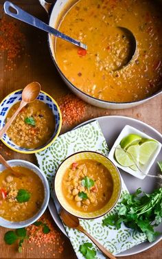 three bowls of soup with spoons and garnishes next to each other