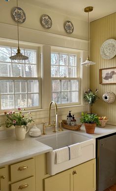 a kitchen with yellow cabinets and white counter tops