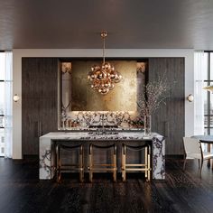 an elegant dining room with marble counter tops and gold chandelier above the table