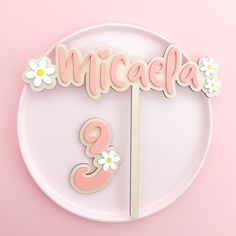 a pink and white plate with a cake topper on it