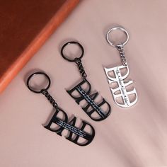 three different styles of metal key chains on a pink surface with the words style 2 written below them