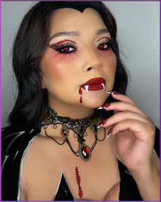 This vampire makeup look seamlessly blends traditional vampire elements with a modern twist. The makeup features meticulously placed red rhinestones above the eyes, adding a touch of glamour and sophistication. The eyes are accentuated with bold eyeliner and dramatic red contact lenses, creating a piercing gaze that is both captivating and unsettling. The skin is flawlessly contoured, with a warm, glowing base that contrasts beautifully with the dark, gothic elements.   Photo credit by: @bereebeauty_ Modern Vampire Art, Red Contact Lenses, Vampire Makeup Ideas, Glossy Red Lipstick, Vampire Makeup Looks, Goth Makeup Looks, Maroon Lipstick, Deep Red Lipsticks, Goth Makeup Tutorial