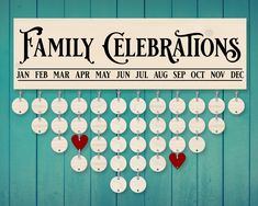 a sign that says family celebrations hanging on a blue wooden wall with red hearts attached to it