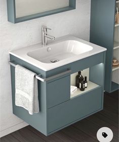 a bathroom sink sitting under a mirror next to a cabinet