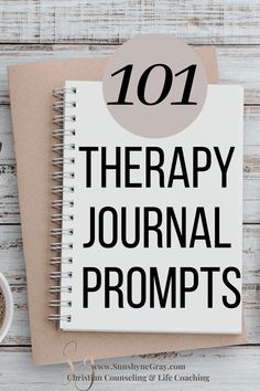 a spiral notebook with the words 101 therapy journal prompts on it next to a cup of coffee