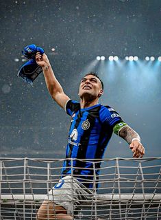 a soccer player is holding his glove up in the air and looking up at the sky