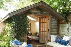 an outdoor living area with couches, chairs and plants on the side of it