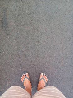 a person wearing sandals standing in the street