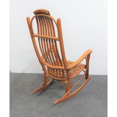 a wooden rocking chair sitting on top of a gray floor