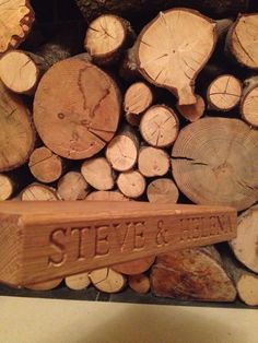 a pile of wood with a sign that says steve and ellen next to some logs