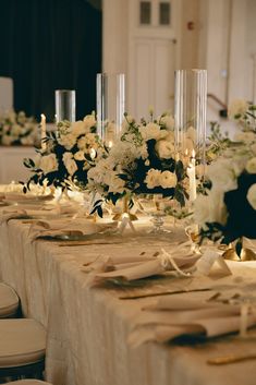 the table is set with white flowers and candles