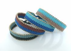 three different colored bracelets sitting on top of each other