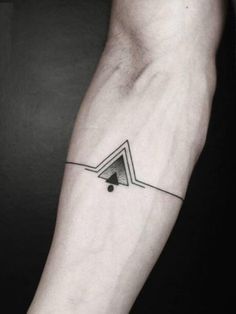 a black and white photo of a person's arm with a triangle tattoo on it