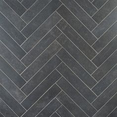 a black and white herringbone tile floor with grey grouting in the middle