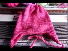 a pink knitted beanie sitting on top of an escalator in a store