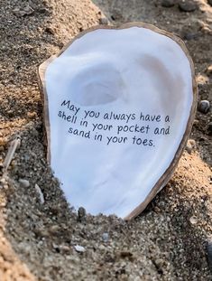 a rock with a message on it sitting in the sand next to some rocks and pebbles