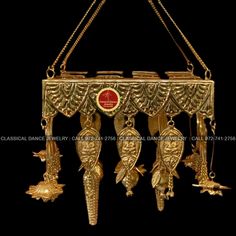 an ornate gold plated shelf with birds hanging from it's sides and other decorations