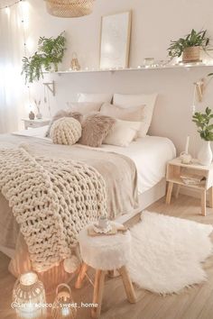 a bedroom with white bedding, pillows and blankets on top of the bedspread