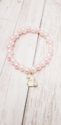 This beautiful pearl bead and bunny Charm bracelets is the perfect gift for someone special. The charm is made of high-quality beads. This makes an excellent gift for yourself or your friends and family members.  The bracelet is made with a high-quality beads that is eco-friendly, durable, and anti-inflammatory. It won't leave your skin green due to marks. Product Details: - Material: stretchy string,pink and gold beads,heart charm and initial charm pearl beads 8 mm.  Please reach out to me for customizations.  Product Packaging: ----------------------------- The bracelets will come in a beautiful organza bag; you can choose this as a gift for someone special. Chocking Hazard Warning, please remember that these beads are a chocking hazard. Do not leave bracelet on during nap time or bed ti Cute Pink Bracelets, Pearl White Pearl Bracelet With 8mm Beads As Gift, Pearl Beaded Bracelets As Gift, Pearl Beaded Bracelets For Gifts, Gift Beaded Bracelet With Pearl Charm, Beaded Bracelet With Pearl Charm As Gift, Pearl Beaded Bracelets With 8mm Beads As A Gift, Pearl Beaded Bracelets With Pearl Drop As Gift, Pearl Drop Beaded Bracelets As Gift