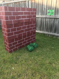 a brick wall and green gloves in the grass