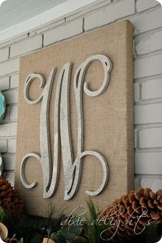 the monogrammed sign is hanging on the wall next to pine cones and other decorations