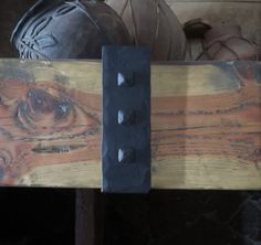 a close up of a piece of wood with some metal rivets on it