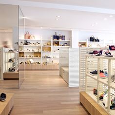 the inside of a shoe store with wooden floors and shelves filled with women's shoes