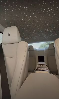 the interior of a car with white leather seats and stars on the ceiling above it