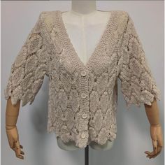 a mannequin wearing a white sweater with crocheted laces on it